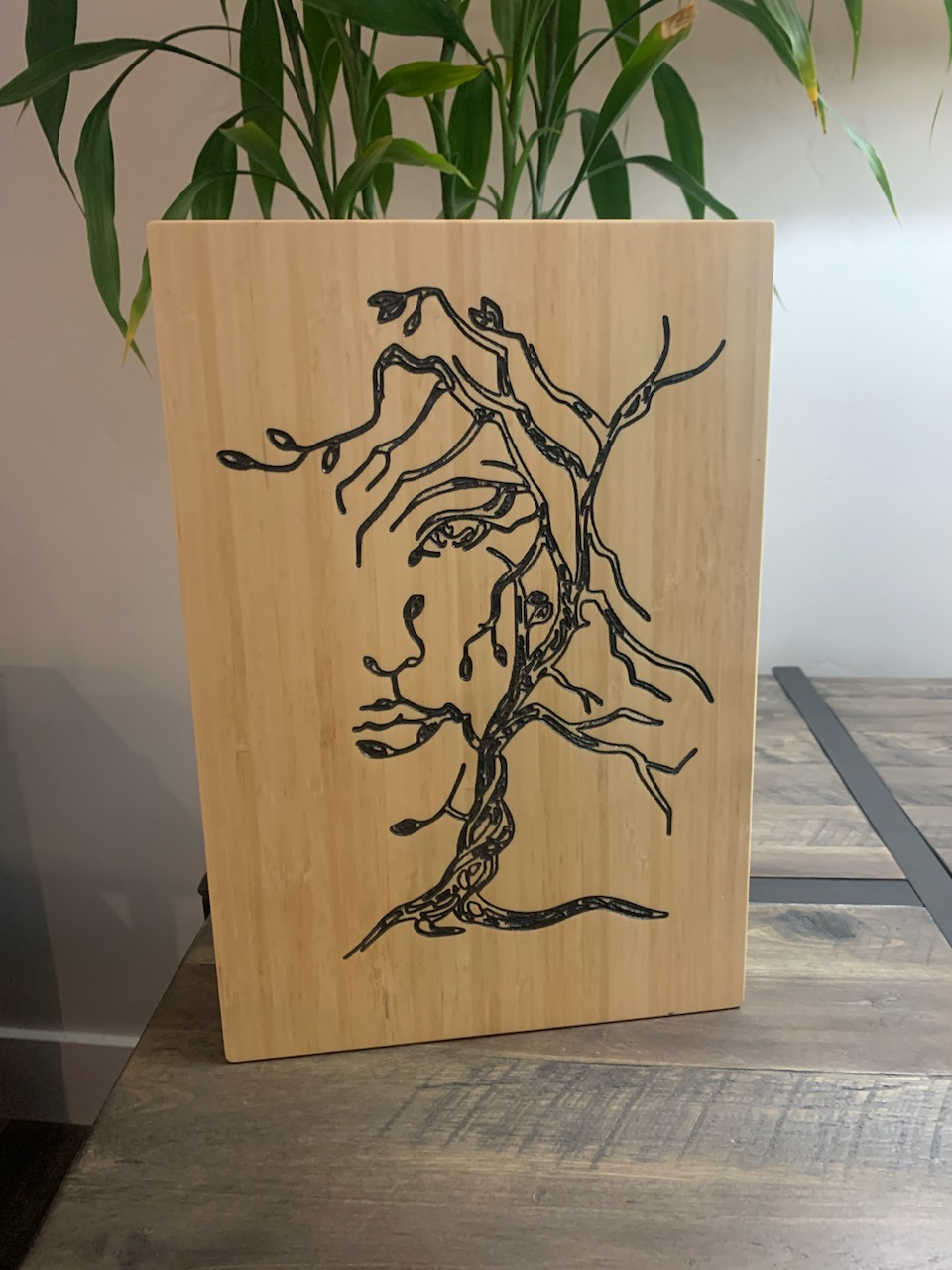 Natural wood panel with laser-carved tree design